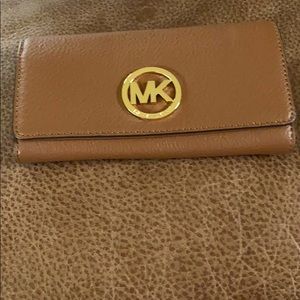 Micheal Kors  . A dark tan colour with gold MK